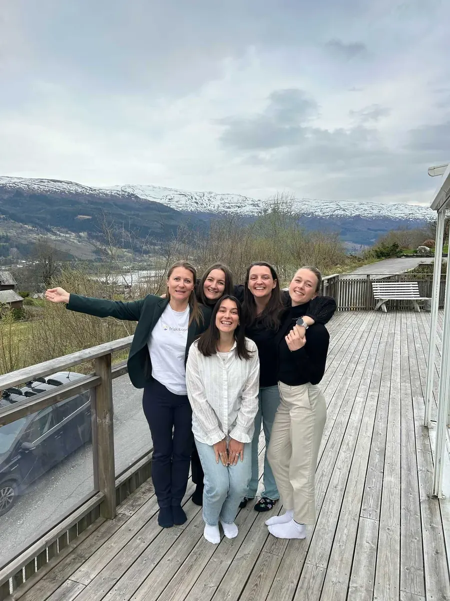 Friskus-teamet på en terrasse med fjellene bak seg